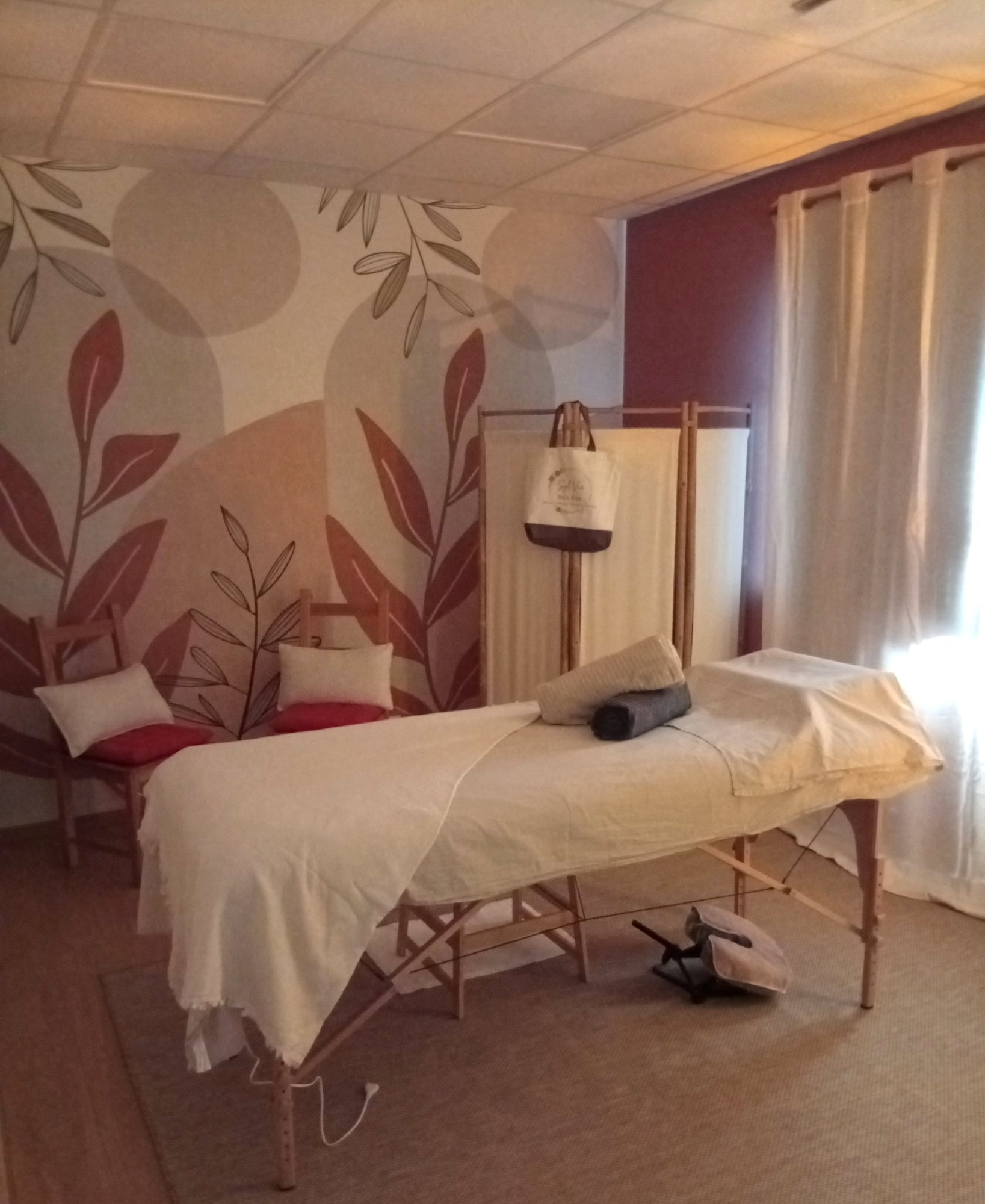 Table de massage devant la fresque végétale de la cabine de Grand Fougeray